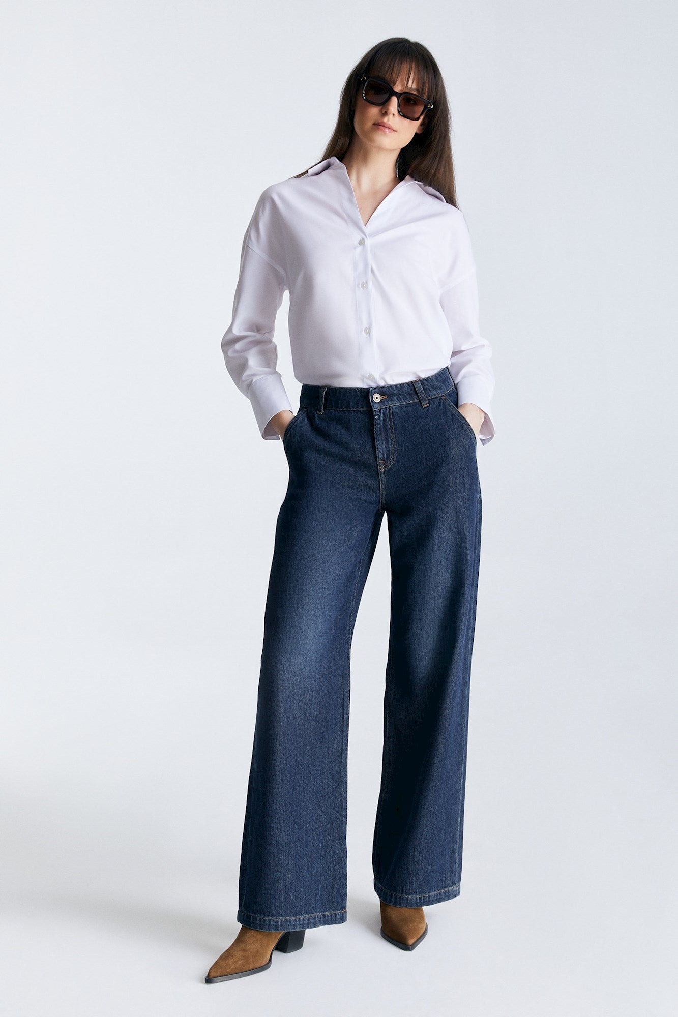 Frontansicht der COJ Maxine Wide Leg Deep Blue Jeans, kombiniert mit einem weißen Hemd und Sonnenbrille.