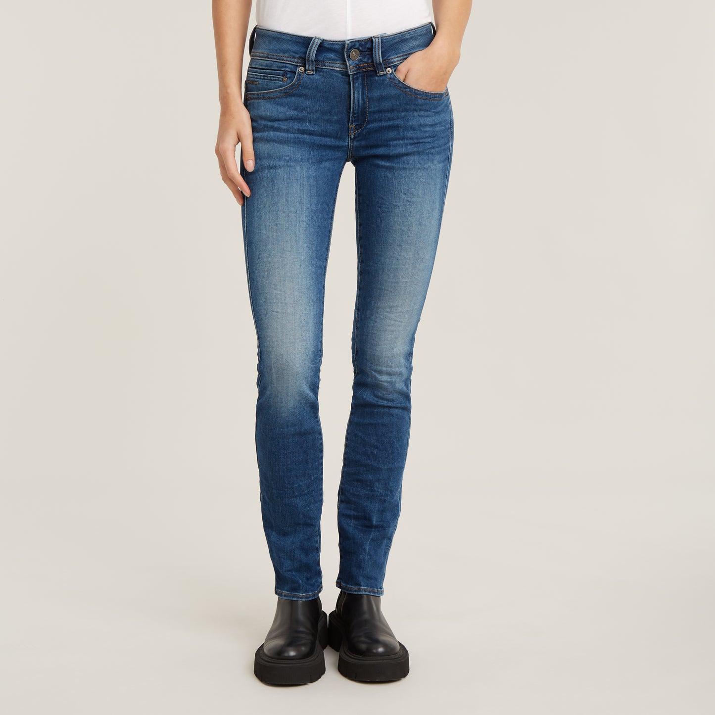 Frontalansicht der G-Star Midge Straight Jeans in Medium Indigo Aged, präsentiert mit minimalistischen schwarzen Boots.