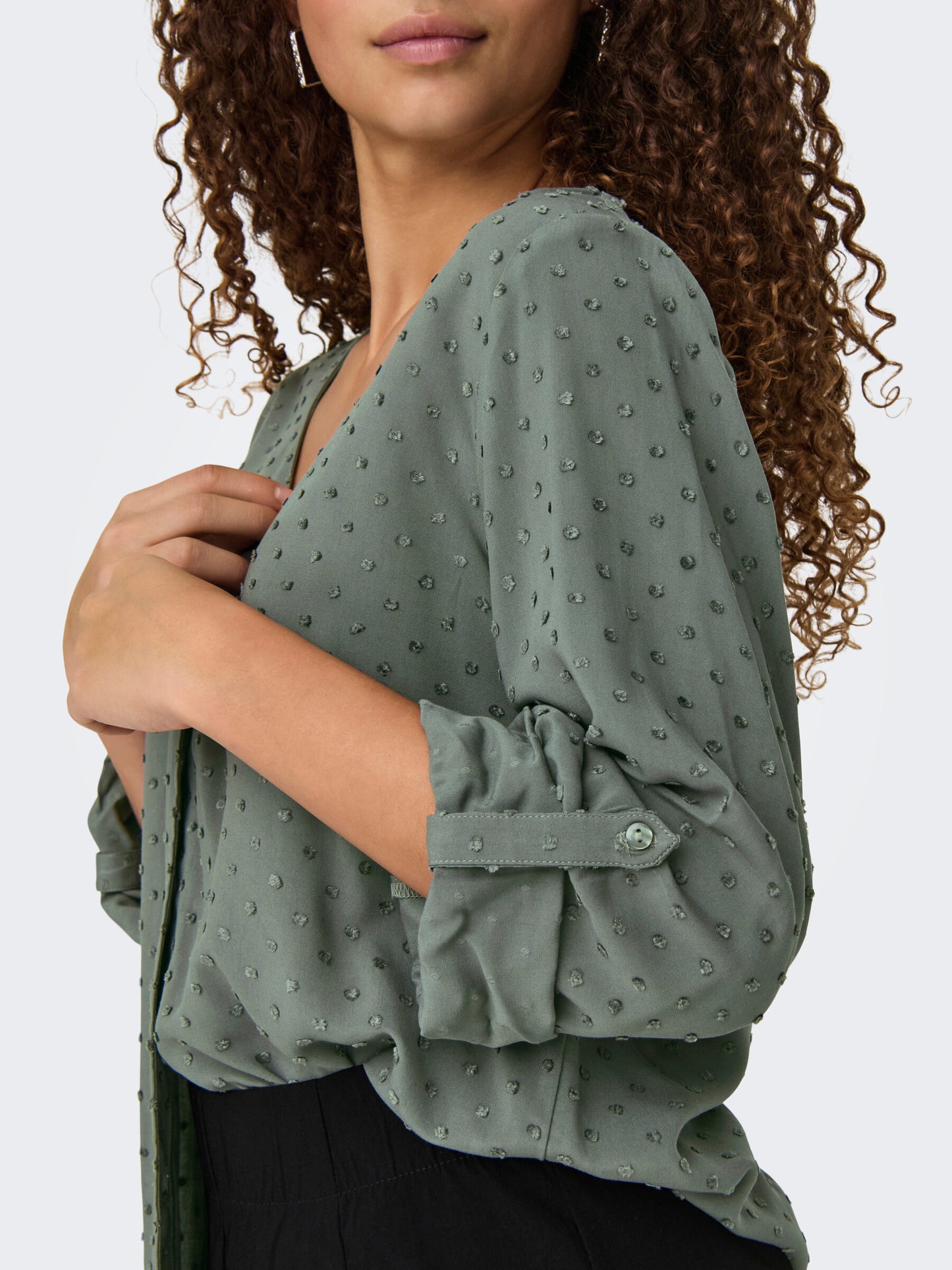 Detailaufnahme des Ärmelbereichs der JDY Diana Bluse in Castor Gray, mit eleganter Punktstruktur und geknöpften Ärmeln.