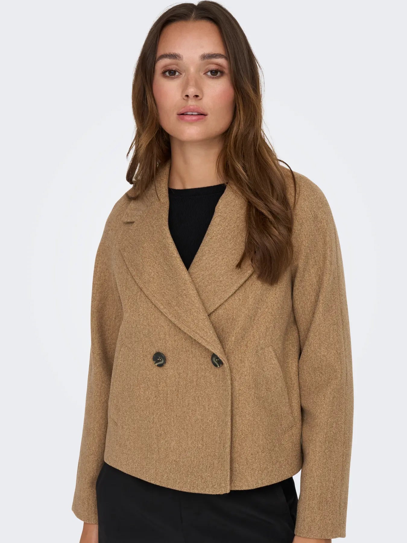 Frau trägt die JDY Viola Life Short Jacket in Camel Melange mit weitem Revers und doppelreihigem Knopfverschluss.