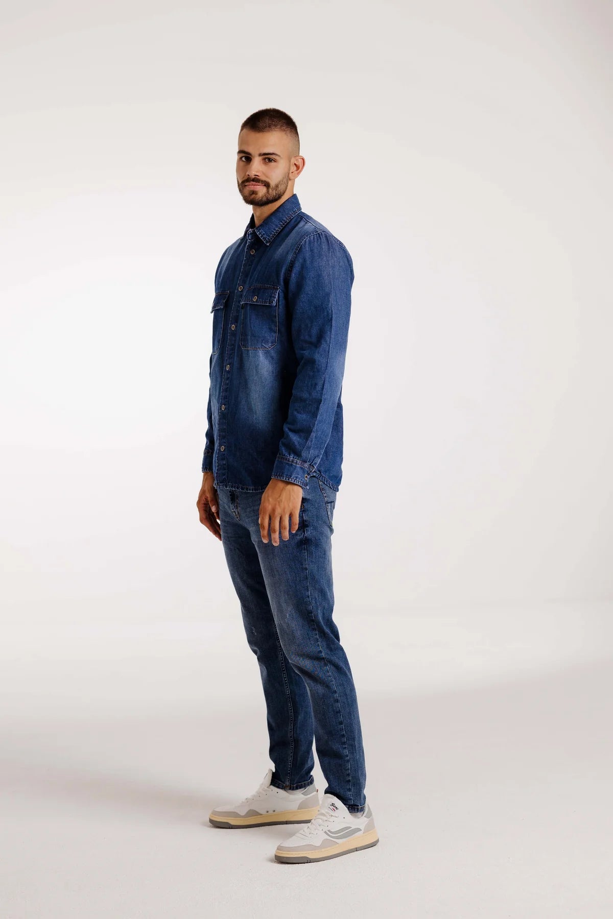 Mann trägt das Kleinigkeit Jürgen Jeansmann Overshirt Dark Blue, kombiniert mit einer Jeans und weißen Sneakers. Perfektes Outfit für einen lässigen Denim-Look.