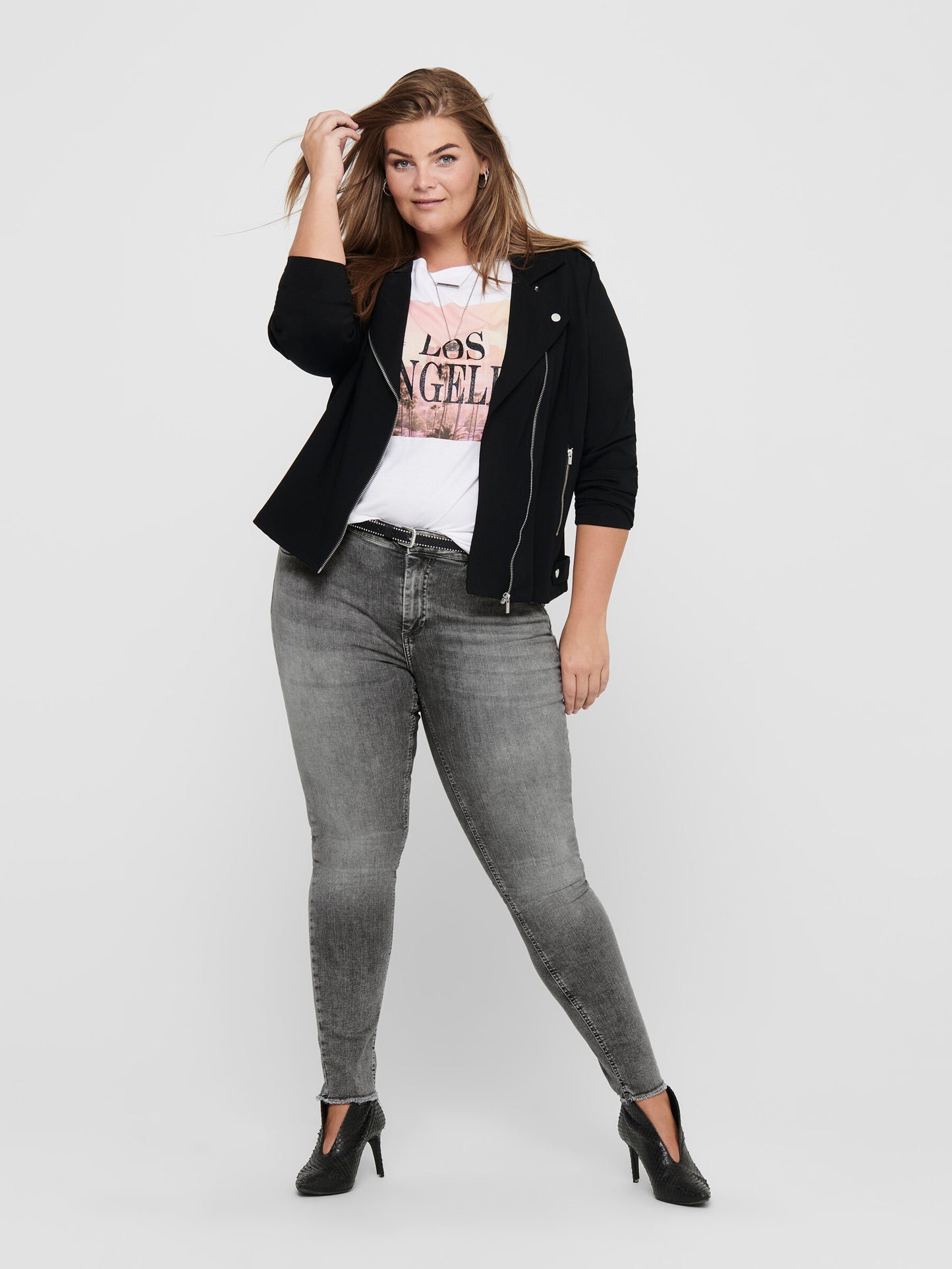 Ganzkörperansicht der Only Carmakoma Carwilly Skinny Grey Jeans, getragen von einem Model mit schwarzer Jacke und weißem T-Shirt. Perfekte graue Skinny Jeans für einen trendigen und eleganten Stil.