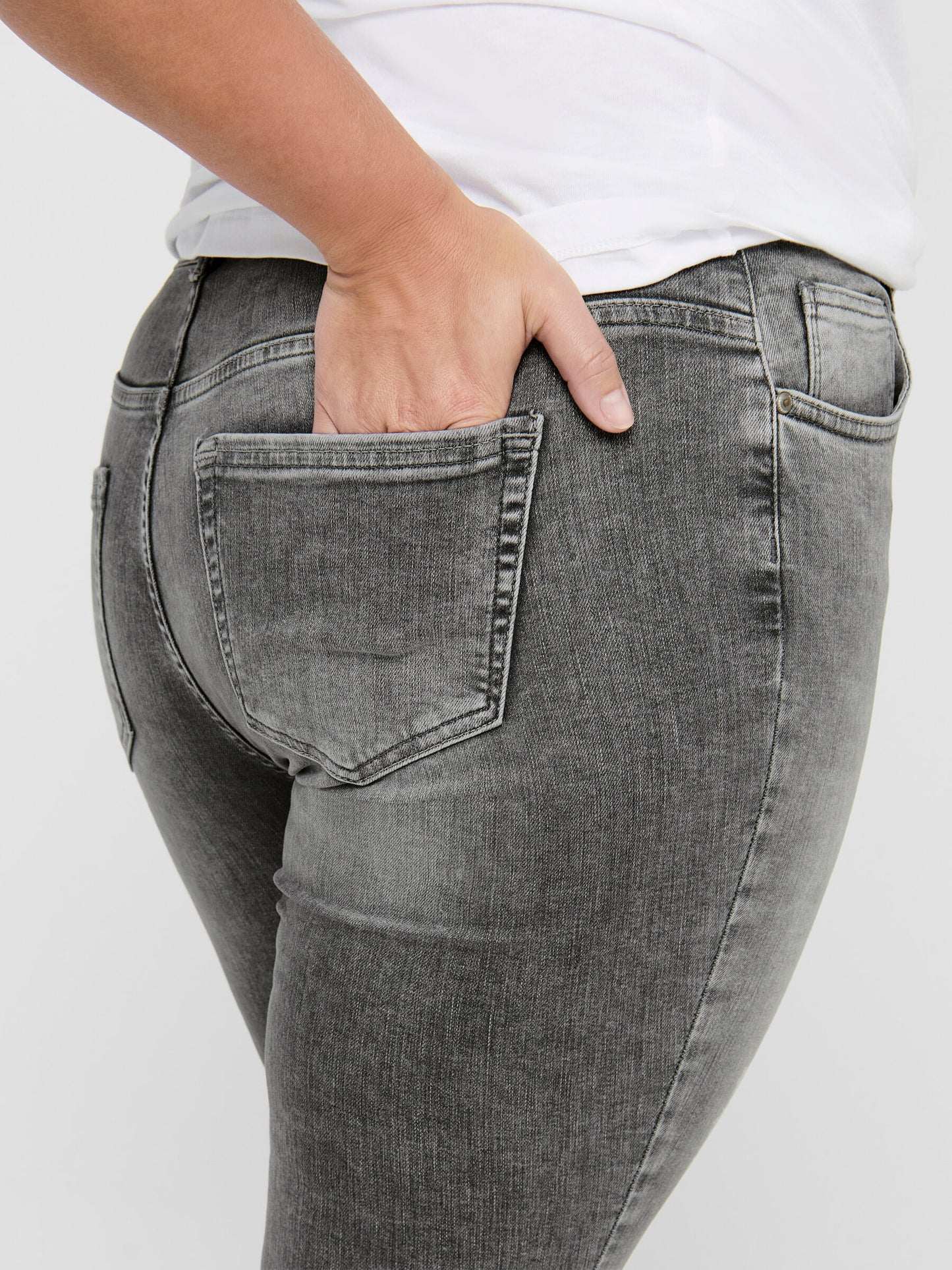 Rückansicht der Only Carmakoma Carwilly Skinny Grey Jeans mit Fokus auf die Gesäßtaschen und die strukturierte graue Waschung.