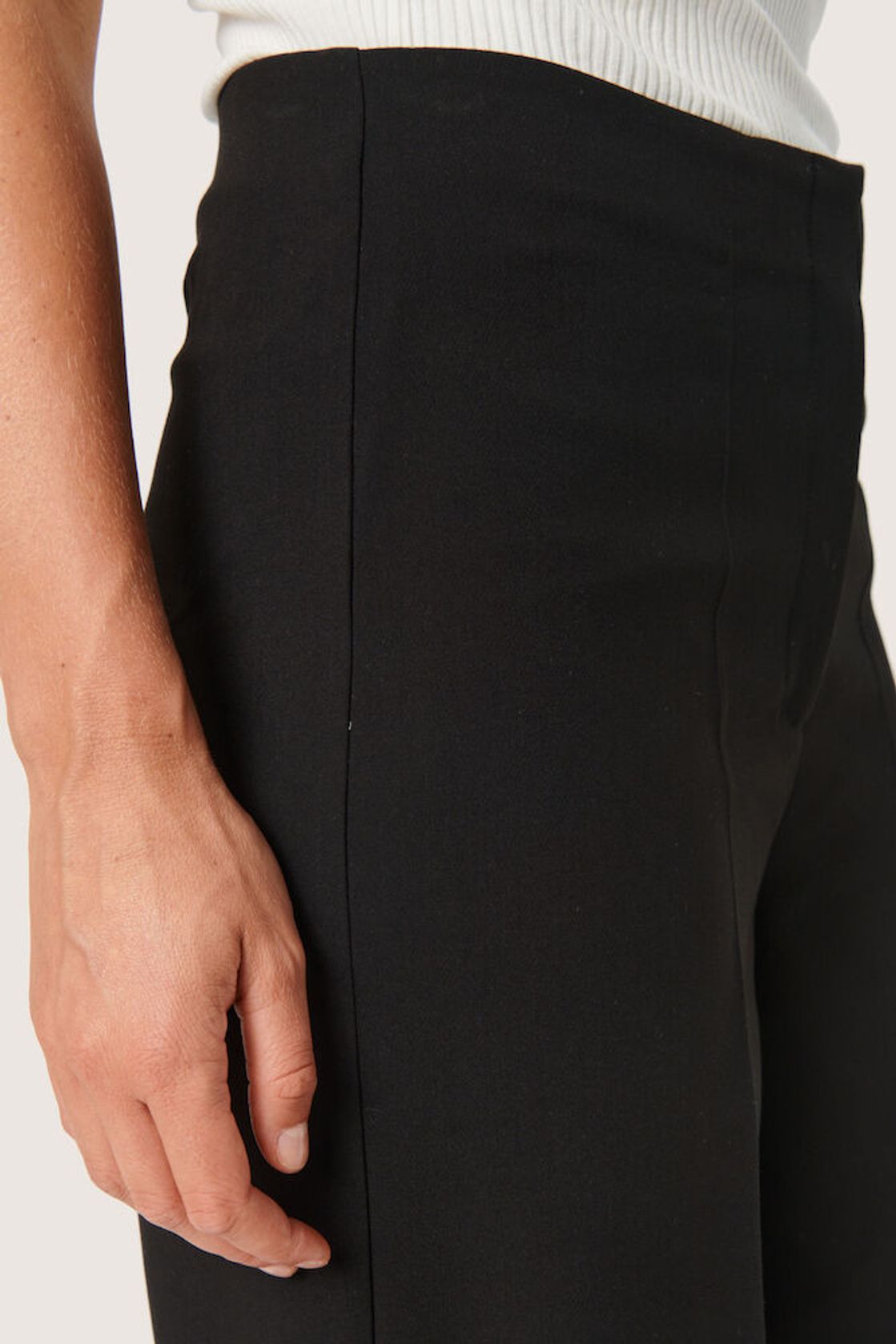 Detailaufnahme der Soaked Corinne Wide Long Pants - Black, hochwertige Stoffstruktur und eleganter Schnitt mit seitlicher Naht.