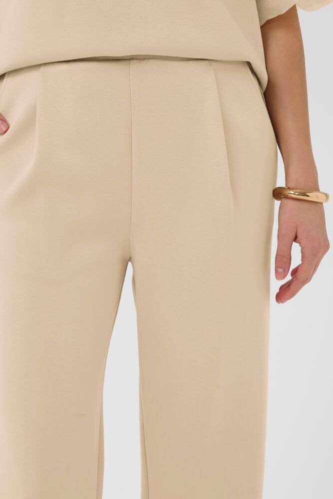 Detailaufnahme der Soaked Marigold Pants - White Pepper mit feiner Stoffstruktur, Bund und elegantem Fall