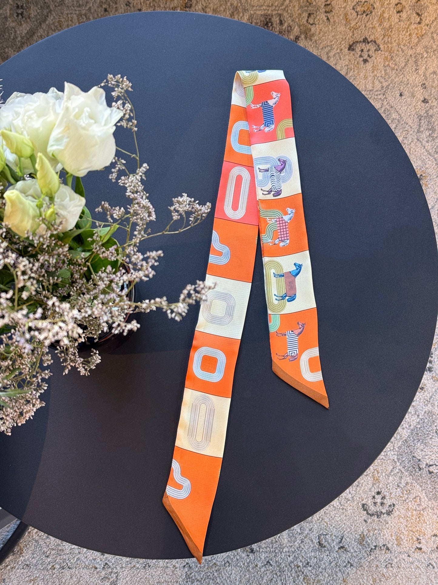 Schmales Twilly-Seidentuch in leuchtendem Orange mit Mosaik-Print und abstrakten Tiermotiven. Perfektes Accessoire für Taschen, Haare oder als Halstuch.