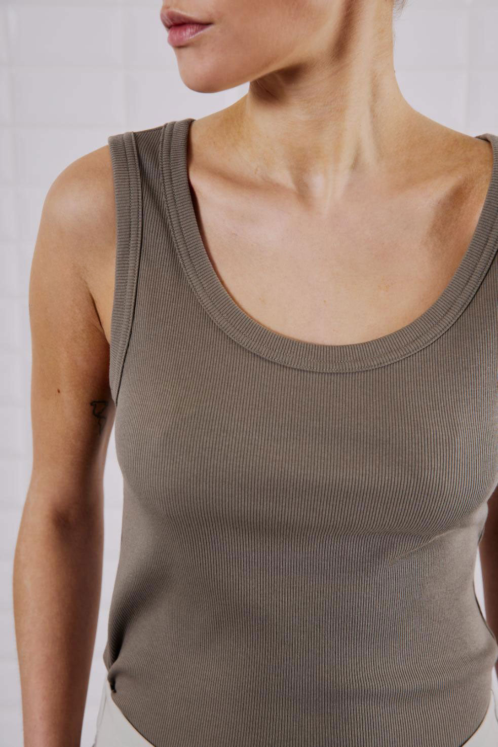 Nahaufnahme des WithBlack Lulu Tank Top Light Stone Grey mit Rippstrick-Textur und tiefem Ausschnitt.