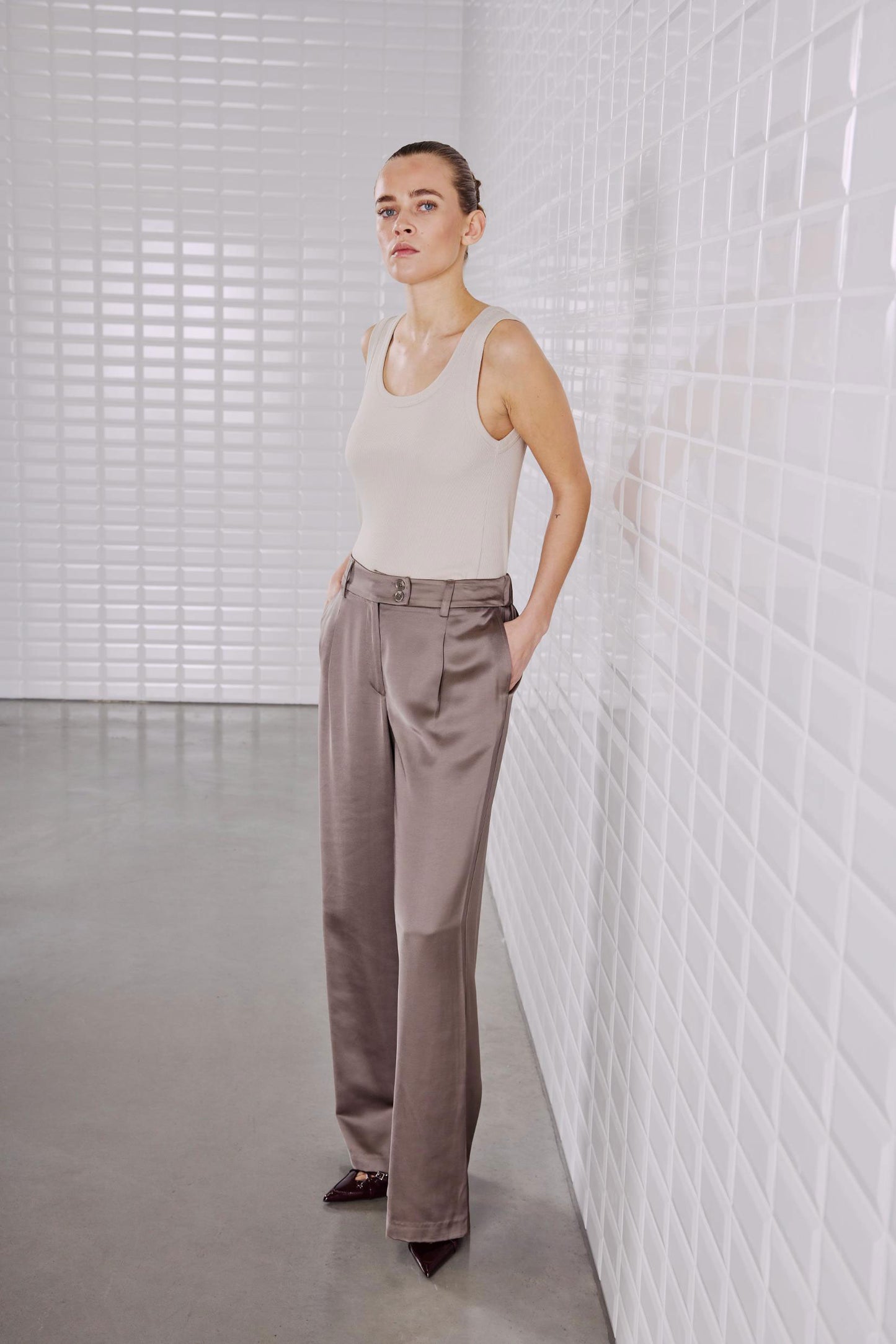 Modell trägt das WithBlack Lulu Tank Top in Silver Lining, ein klassisches geripptes Tank-Top mit tiefem Ausschnitt.