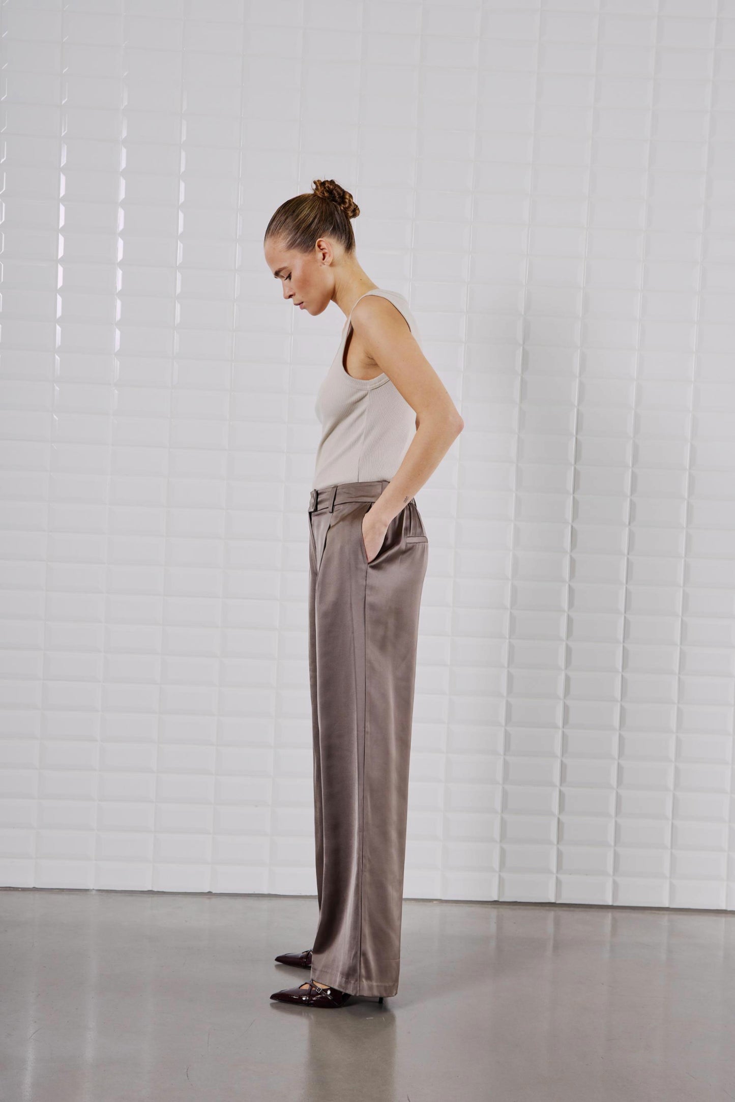 Seitenansicht des WithBlack Lulu Tank Tops in Silver Lining, kombiniert mit einer weiten Satin-Hose.