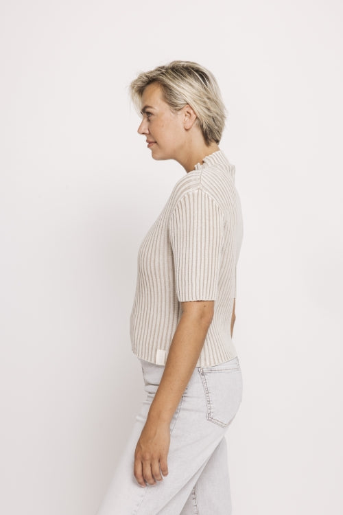 Zhrill Arden - Sand, figurbetontes Rippstrick-Shirt mit Stehkragen in Sandfarbe, Seitenansicht mit kurzer Ärmelpartie und modernem Fit.