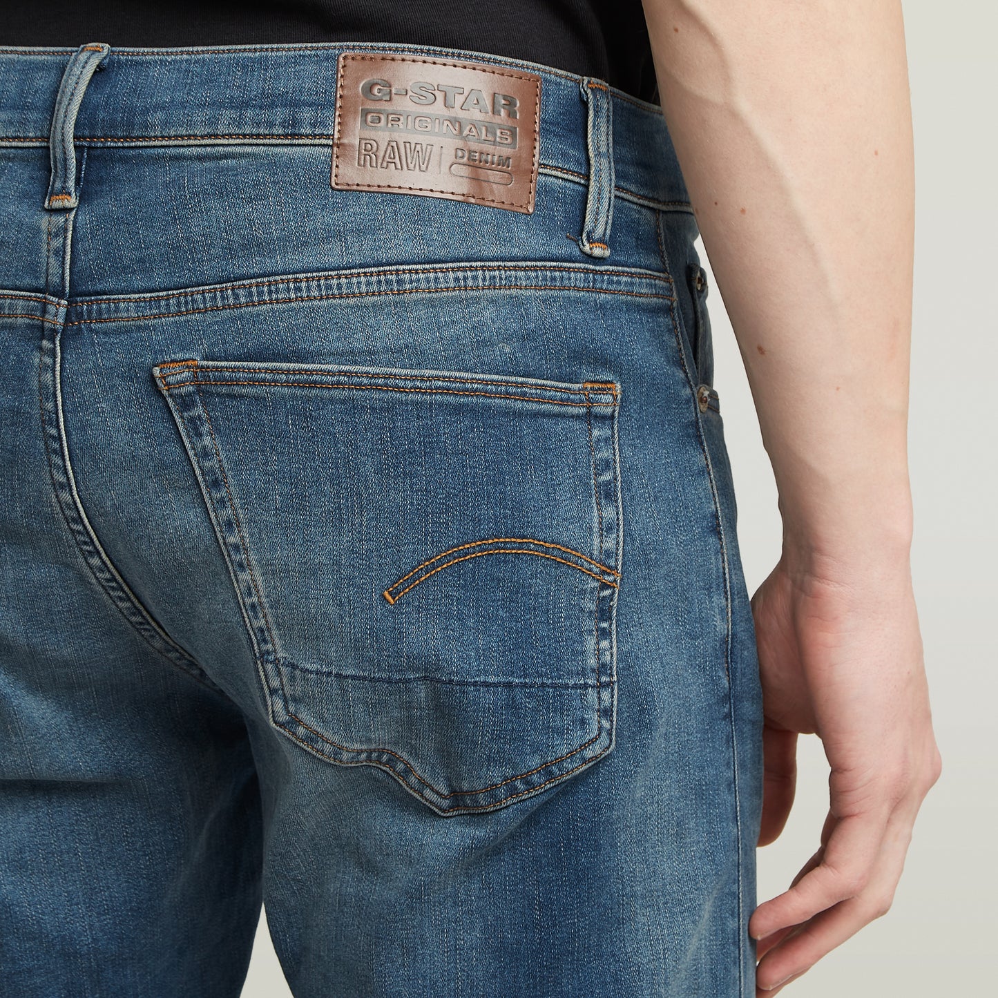 Detailaufnahme des G-Star RAW Labels auf der Rückseite der 3301 Slim Jeans, gefertigt aus lederähnlichem Papiermaterial.