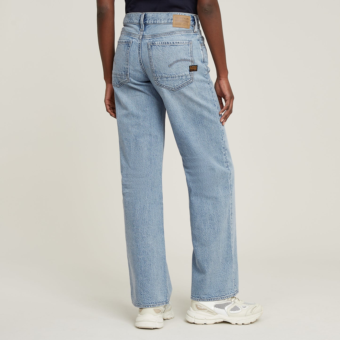 Rückansicht der G-Star Judee Loose Jeans in Sun Faded Cloudburst, getragen von einem Modell mit Sneakers.