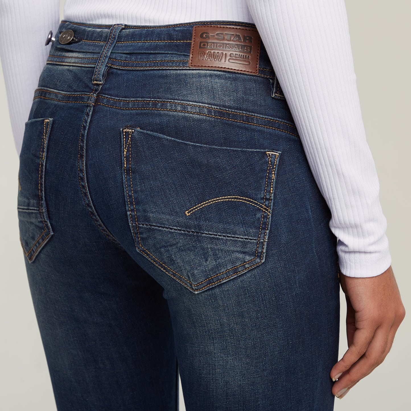 Detailansicht der Gesäßtaschen der G-Star Midge Bootcut Dark Aged Jeans mit Markenlabel und dezenter Kontrastnaht.