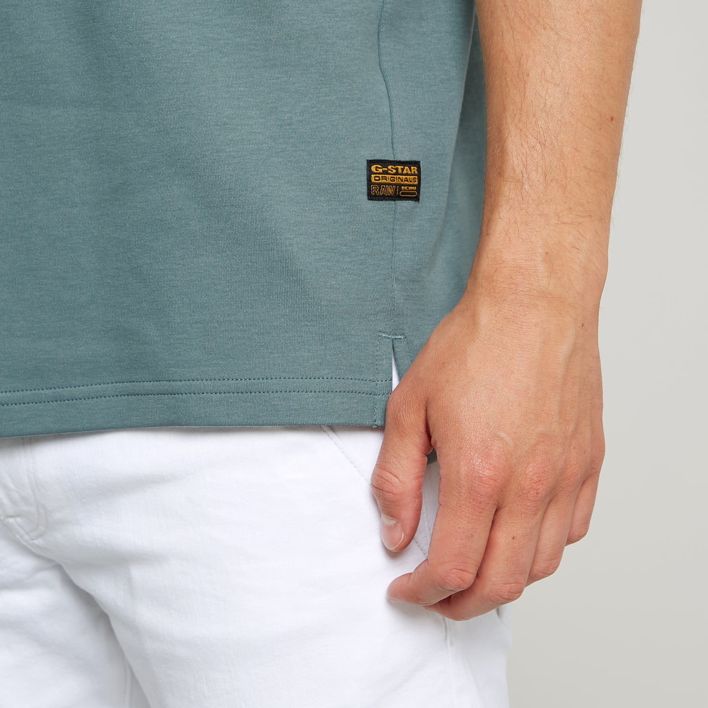 Nahaufnahme des G-Star Nifous T-Shirts in Bolt Grey mit kleinem G-Star RAW Logo-Label am unteren Saum.