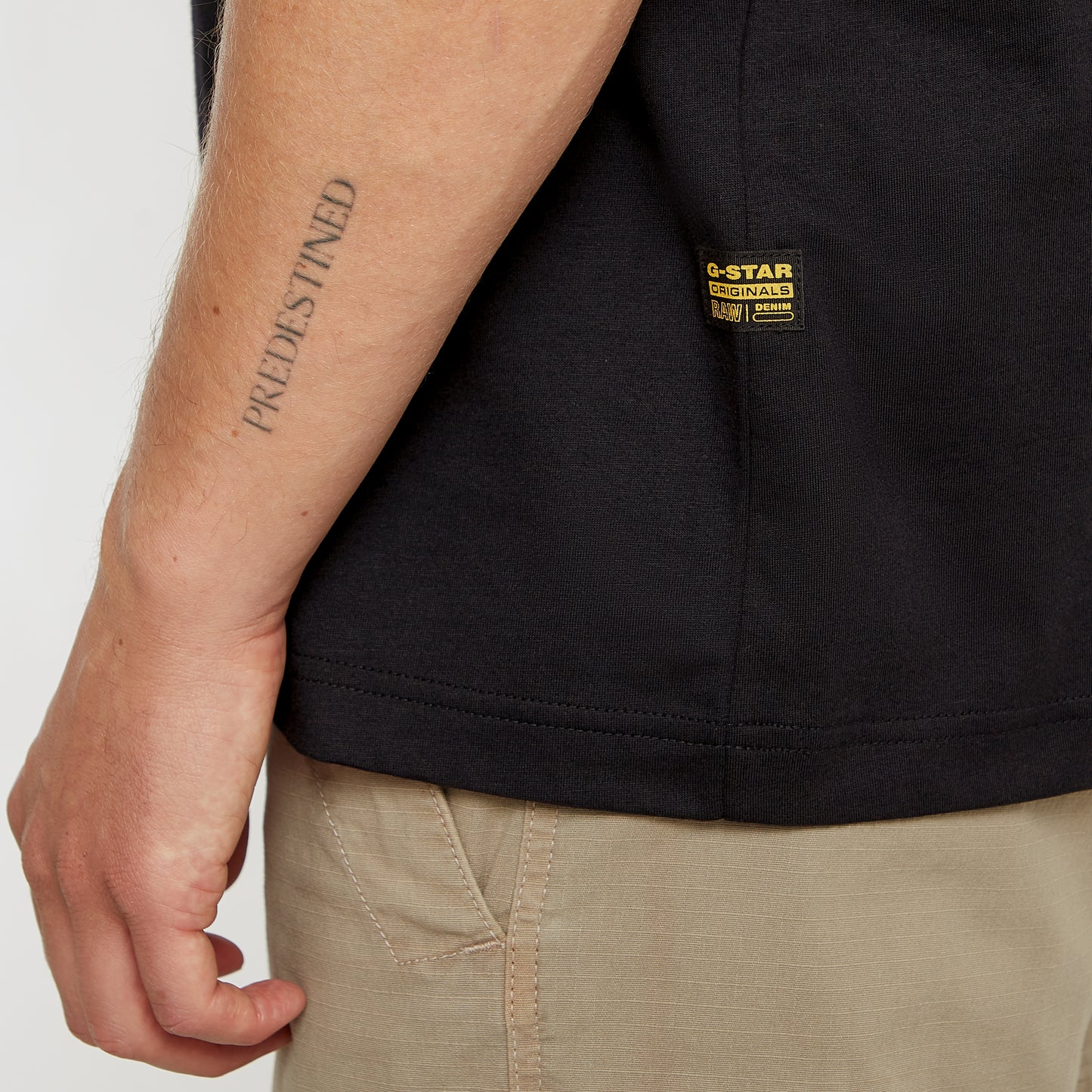 G-Star Originals T-Shirt Dark Black – Nahaufnahme des gewebten G-Star Originals Labels an der Seitennaht.