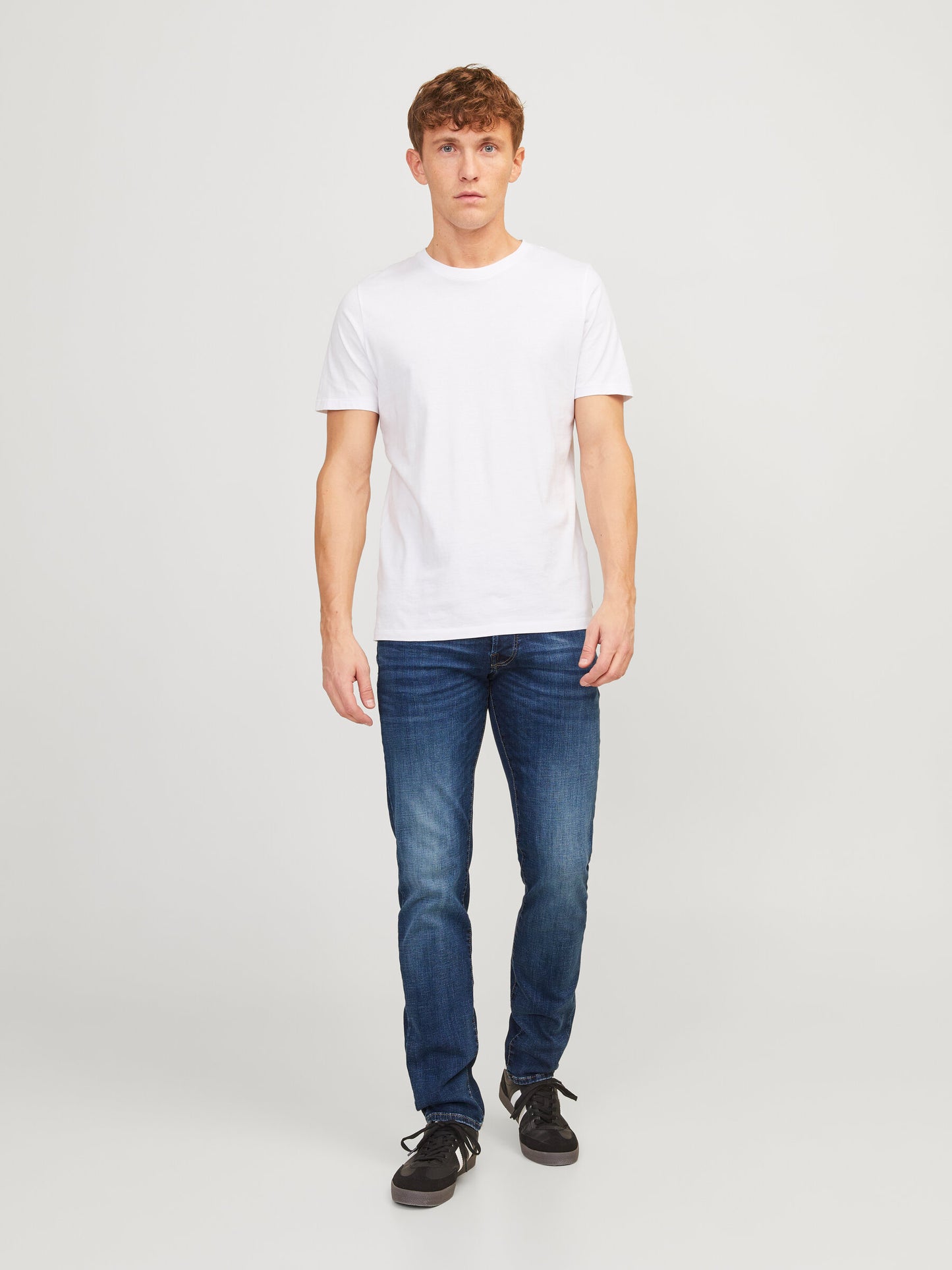 Frontale Ansicht eines Models in der Jack & Jones Glenn Slim Blue Denim Jeans in Blau, kombiniert mit einem weißen T-Shirt.