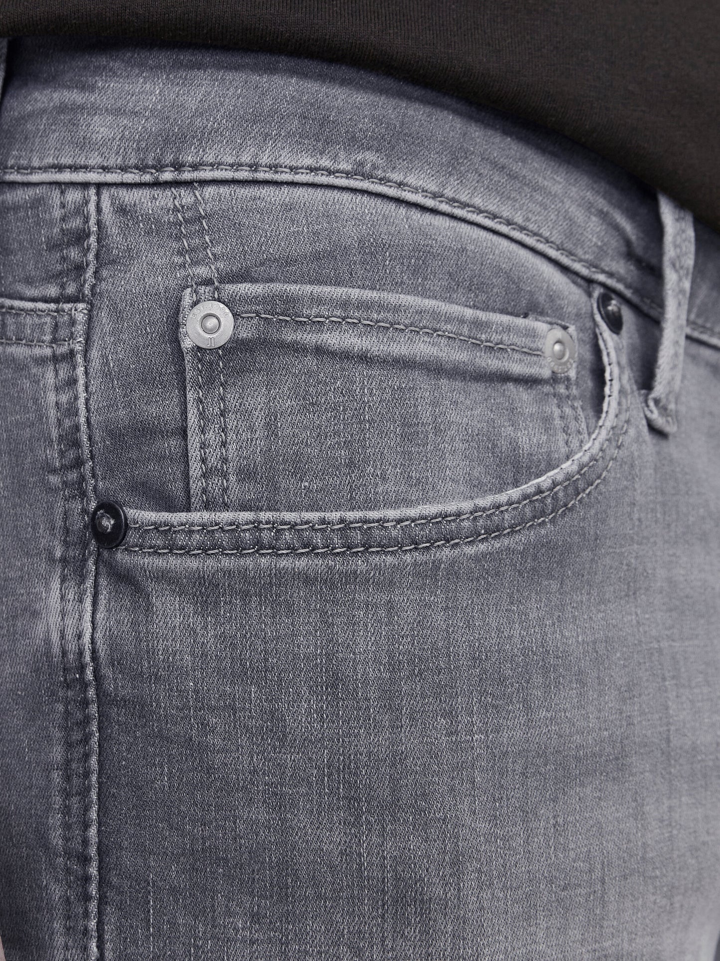 Nahaufnahme der Jack & Jones Glenn Slim Grey Denim mit detaillierter Ansicht der Vordertasche in grauem Denim-Stoff.