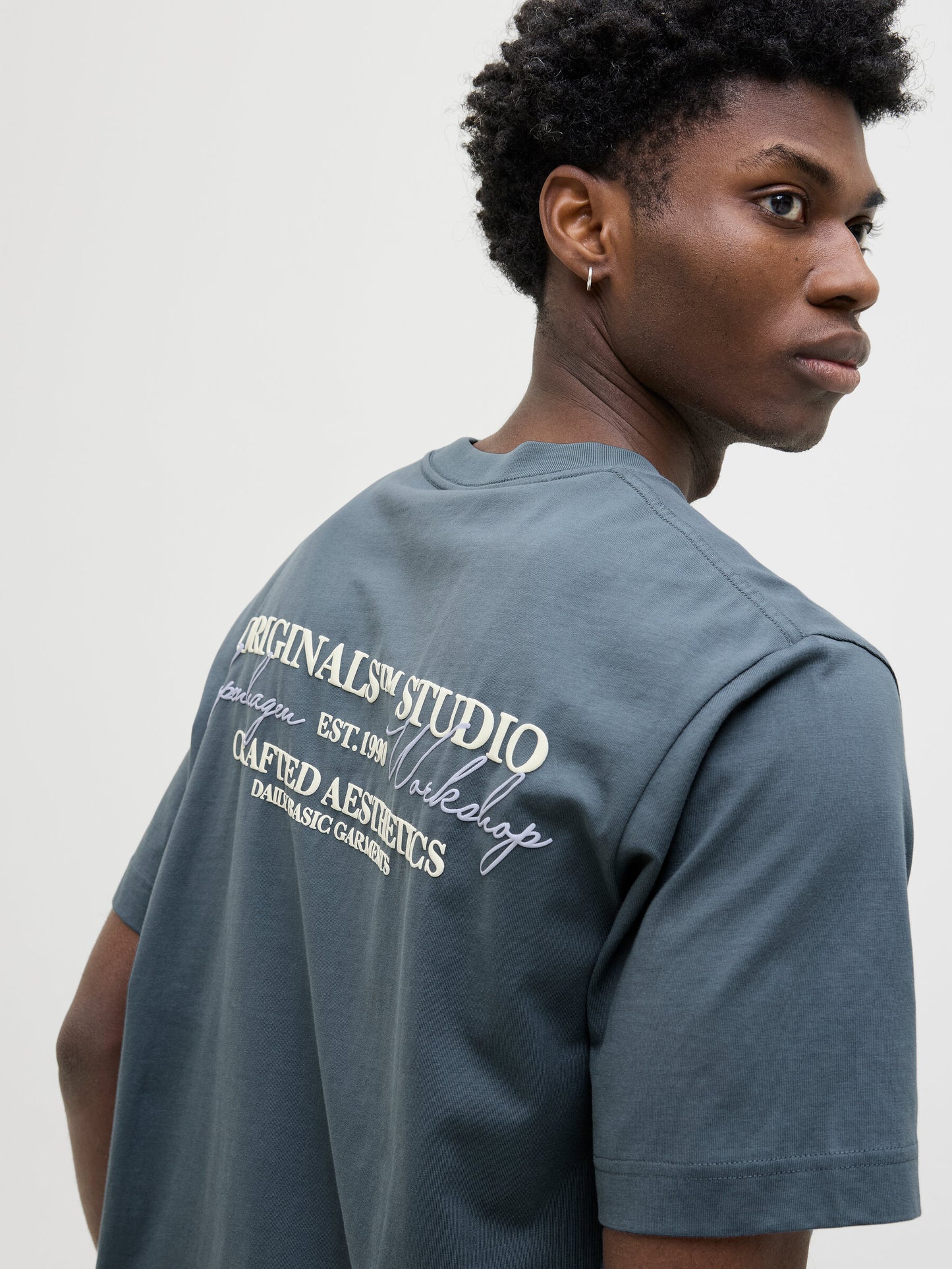 Rückansicht des Jack&Jones Rislington T-Shirts in Stormy Weather mit großem Aufdruck und stilvollem Schriftzug.
