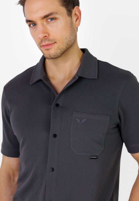 Detailaufnahme der Brusttasche und Struktur beim Kleinigkeit Relaxel Schulz Shirt - Asphalt Grey mit dezentem Kleinigkeit Label und Doppelfeder-Stitching.