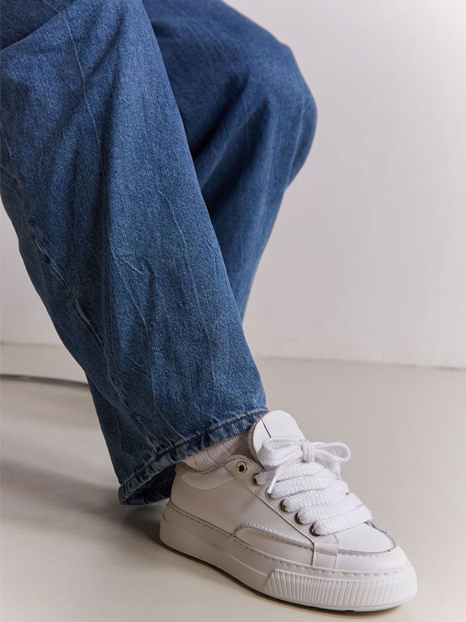 Nubikk Caldera Tora White Sneaker kombiniert mit einer Jeans für einen lässigen Look.