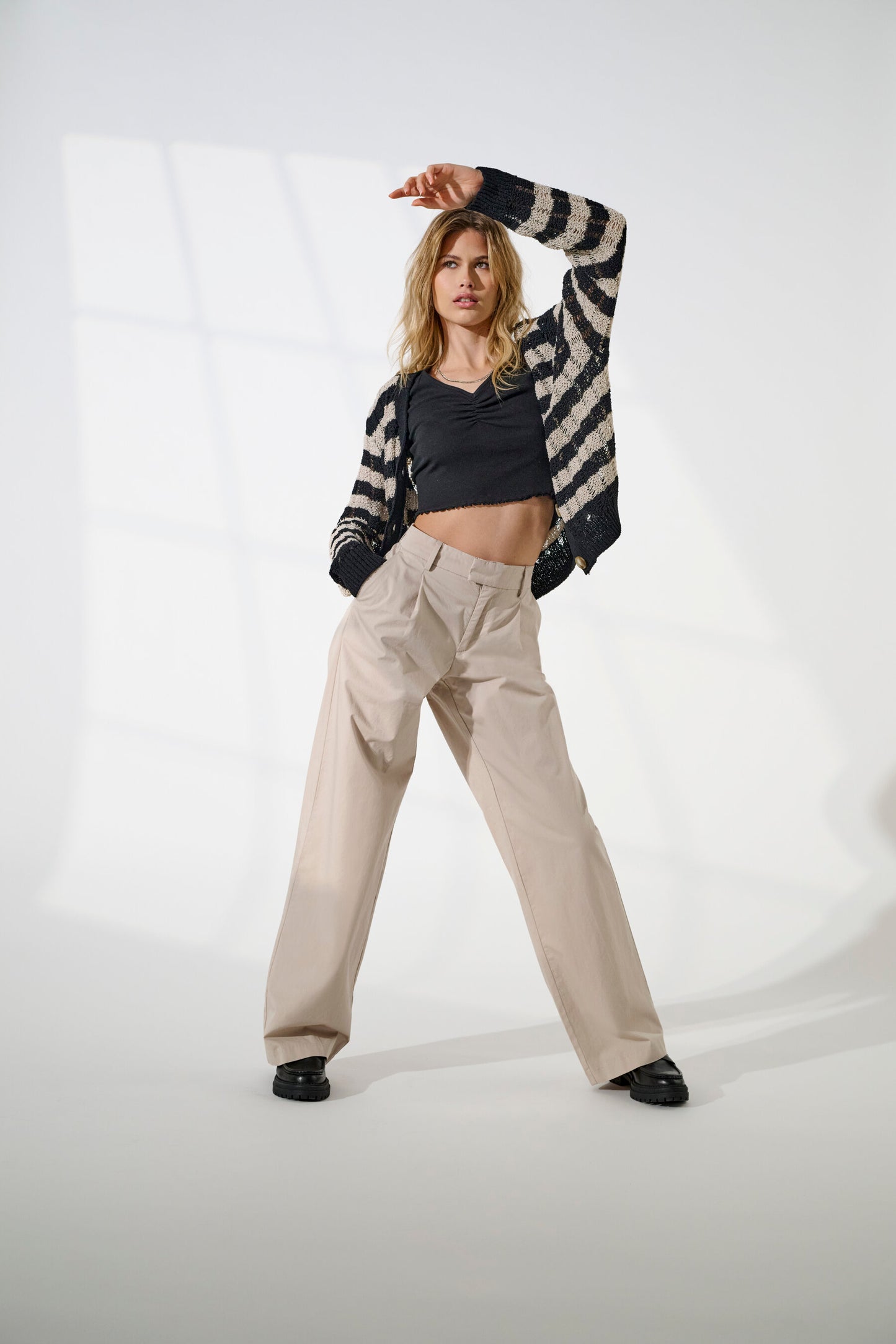 Modell trägt den Only Capri Cardigan kombiniert mit beigen Hosen und schwarzem Oberteil.