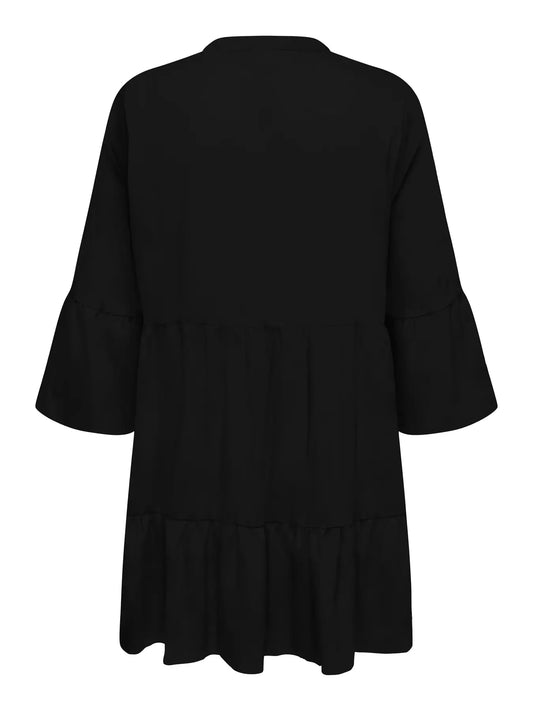 Rückansicht des Only Carmakoma Havana 3/4 Tunic Dress - Black mit fließendem Schnitt und abgestuften Volant-Details.