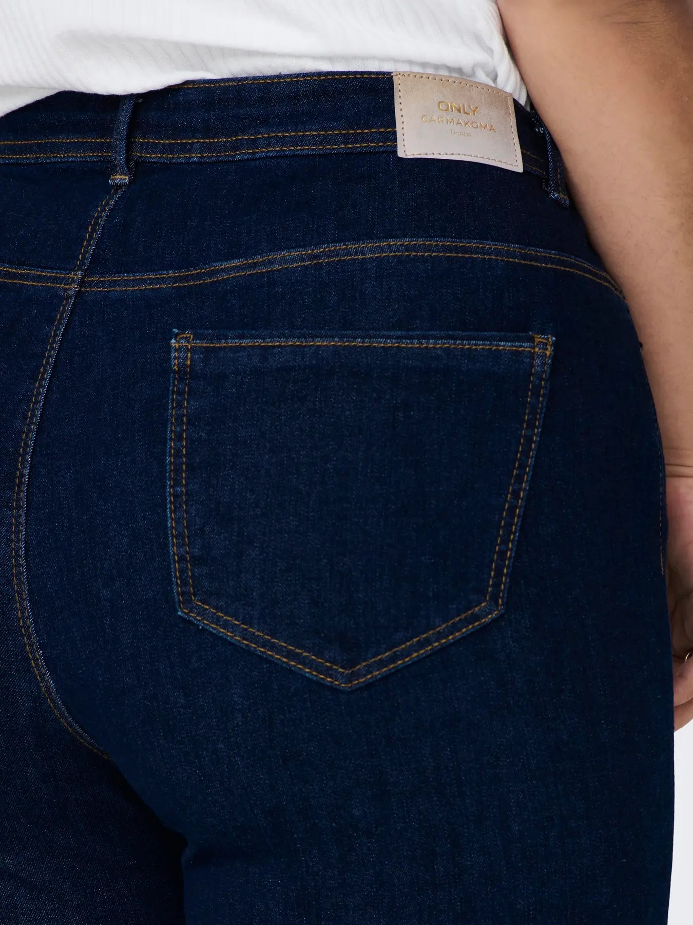 Detailaufnahme Gesäßtasche der Only Carmakoma Sally - High Waist Flared - Dark Blue Jeans – mit Labelpatch und Kontrastnähten