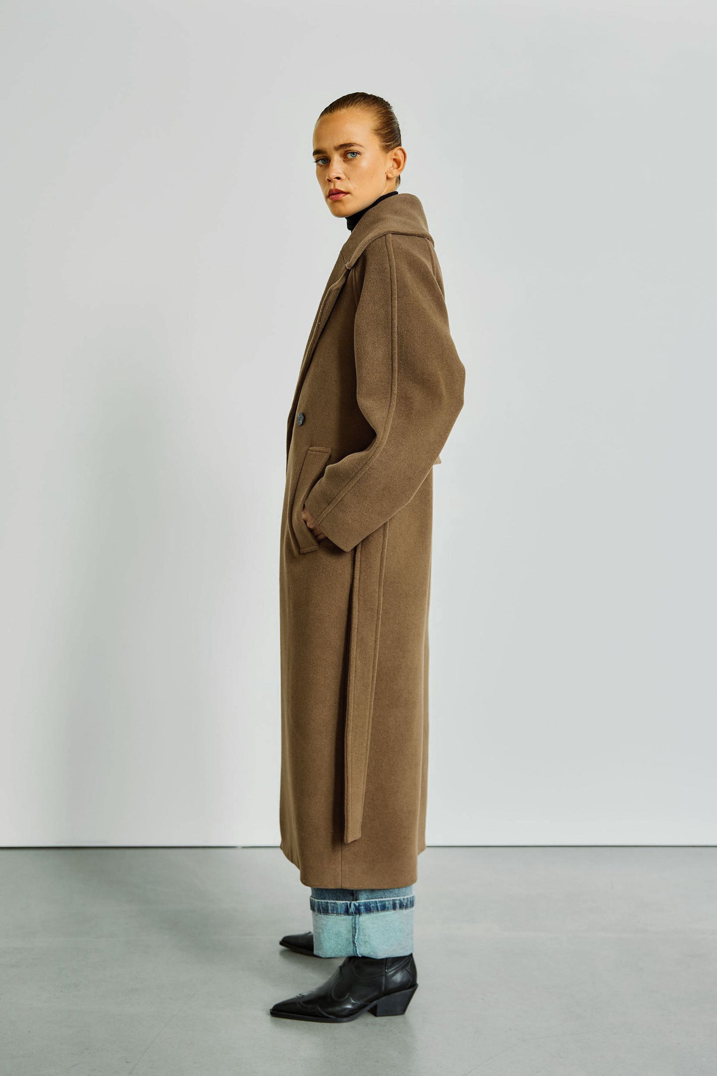 Seitenansicht des WithBlack Brooklyn Wollmantels in Monks Robe, klassische Silhouette mit breitem Revers und Gürtel.