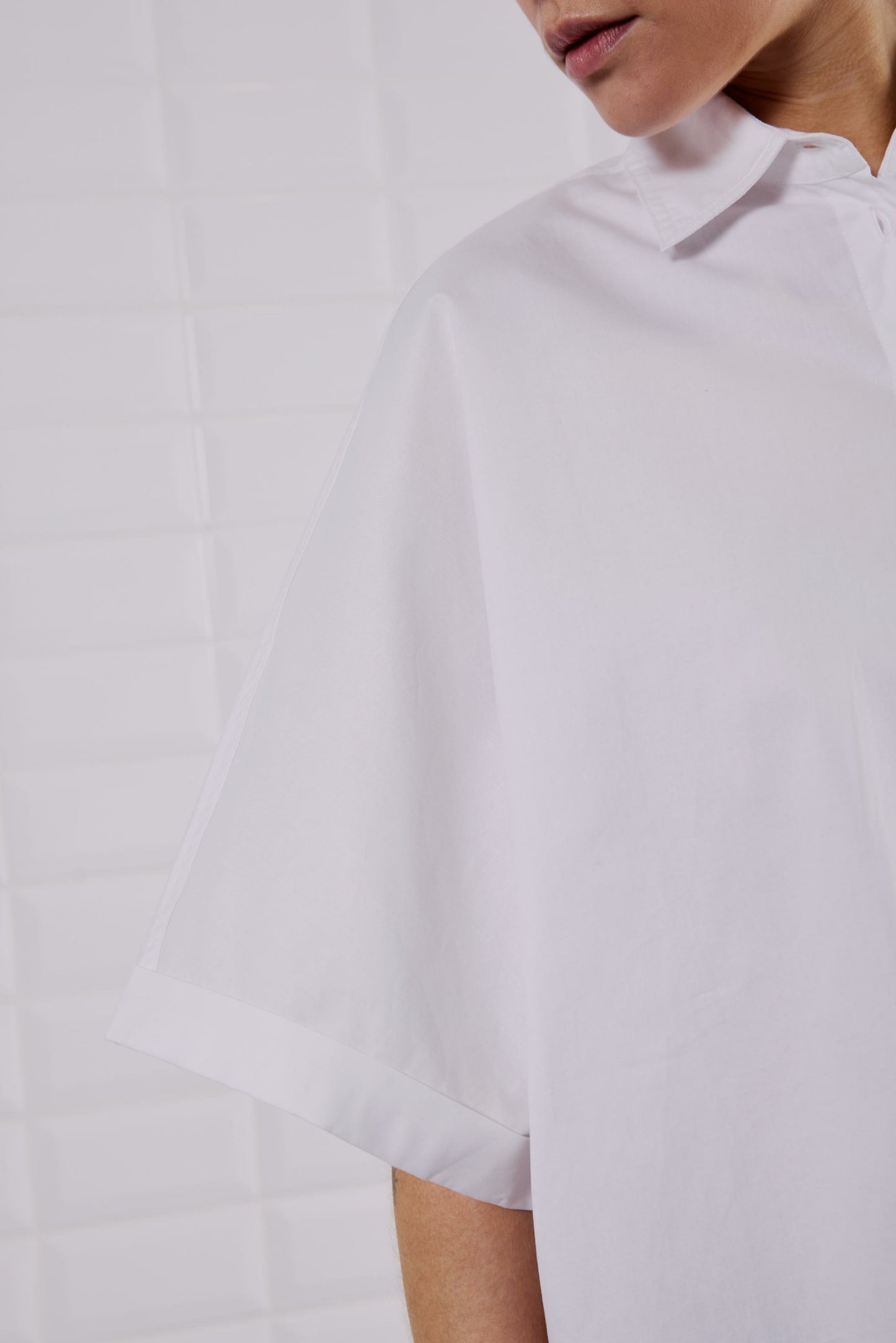 Nahaufnahme des WithBlack Quin Batsleeve Shirt White mit umgeschlagenen Fledermausärmeln.