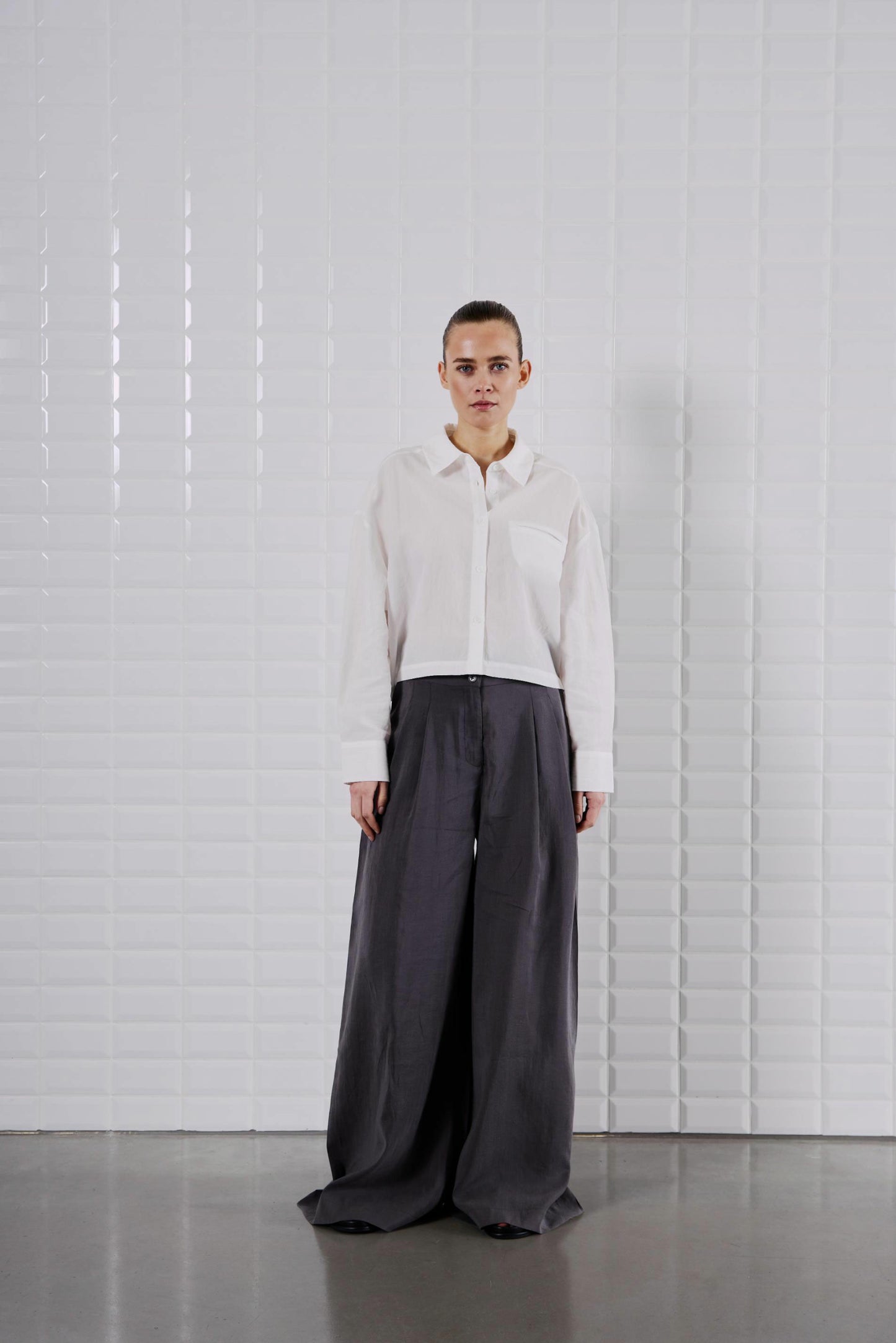 Komplette Ansicht des WithBlack Quinie Cropped Shirt White mit weiter schwarzer Hose, minimalistischer Look.