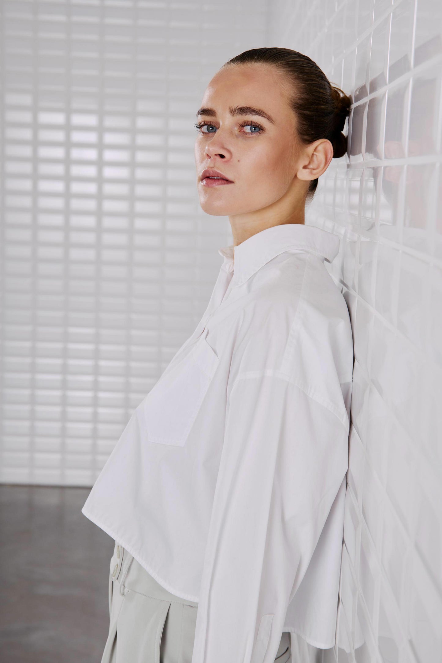 Nahaufnahme des WithBlack Shorty Soft Cropped Shirt in Weiß mit klassischem Kragen und Brusttasche.
