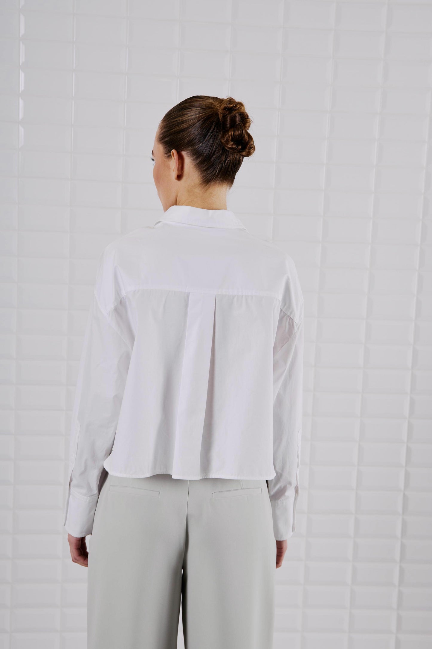 Rückansicht des WithBlack Shorty Soft Cropped Shirt in Weiß, locker fallend mit taillierter Länge.