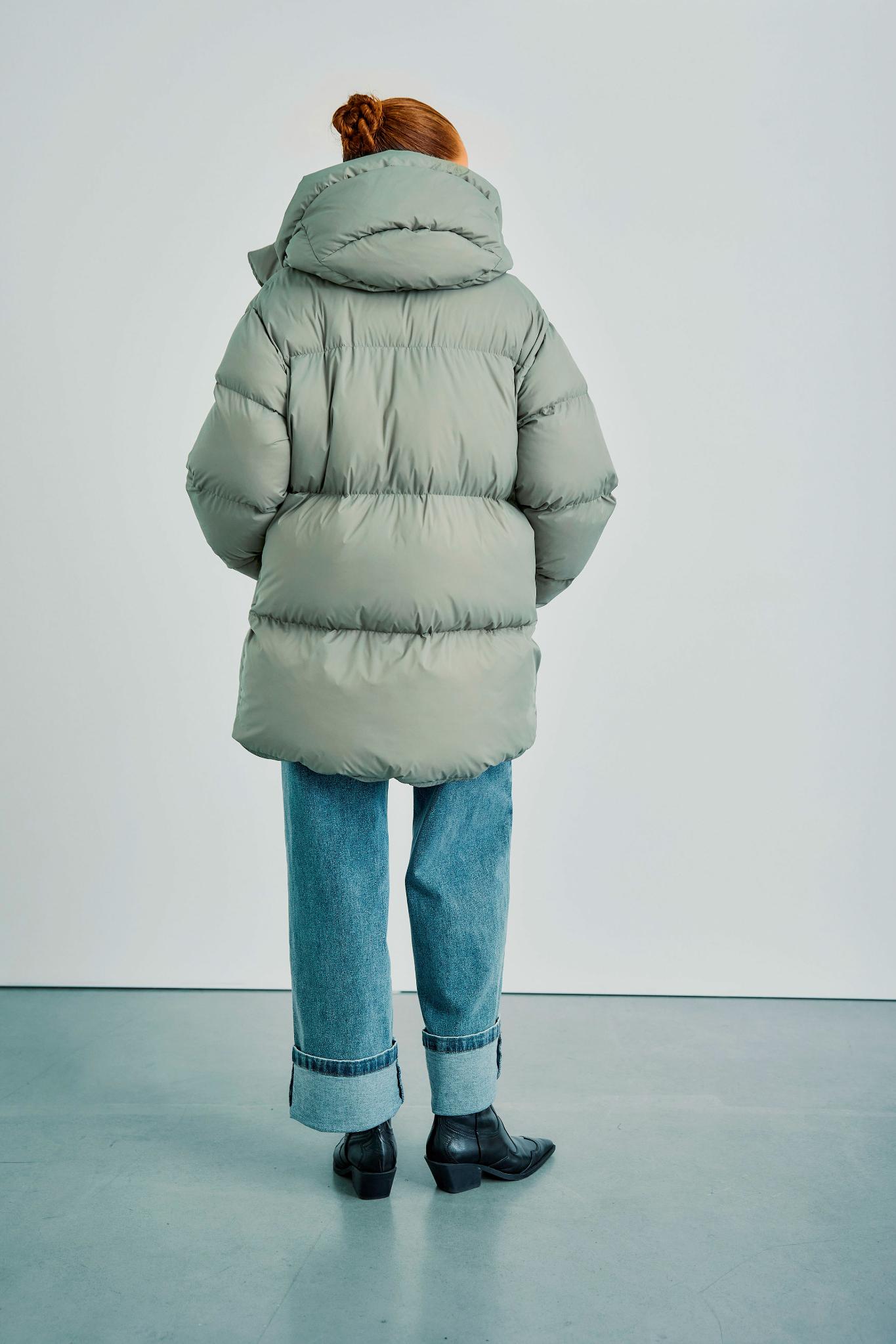 Rückansicht der WithBlack Vanessa Puffer Jacket in Ice Green, präsentiert mit weit geschnittenen Jeans und Stiefeletten.