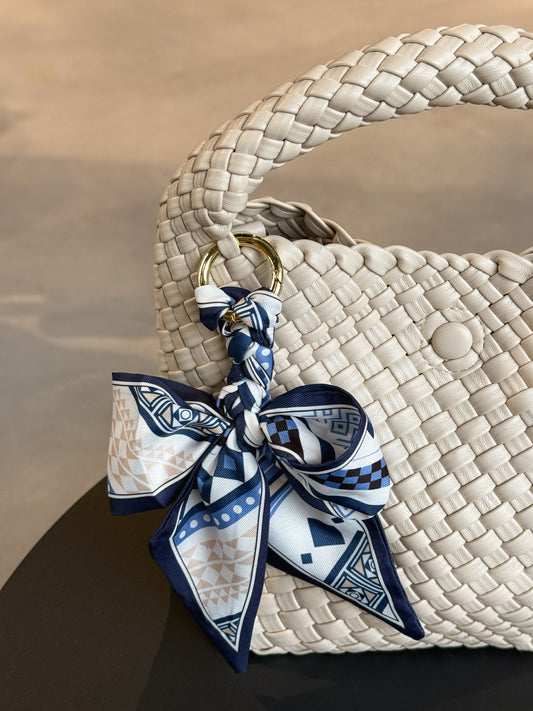 Braided Bow Charm in geflochtener Schleifenform, befestigt an einer Tasche – modischer Accessoire-Trend aus Twill in blauem Muster