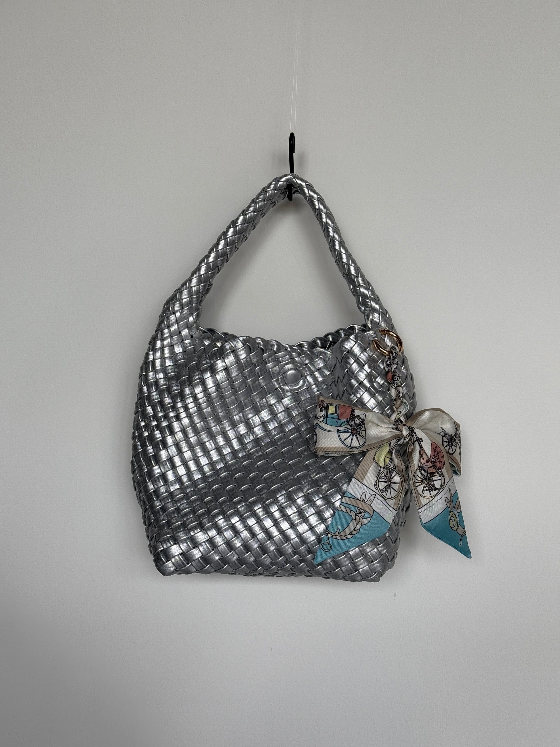 Glänzende Braided Mini Bag in Silber mit verspieltem Seidentuch in Blau und Beige, ideal für trendbewusste Looks mit Eyecatcher-Effekt.