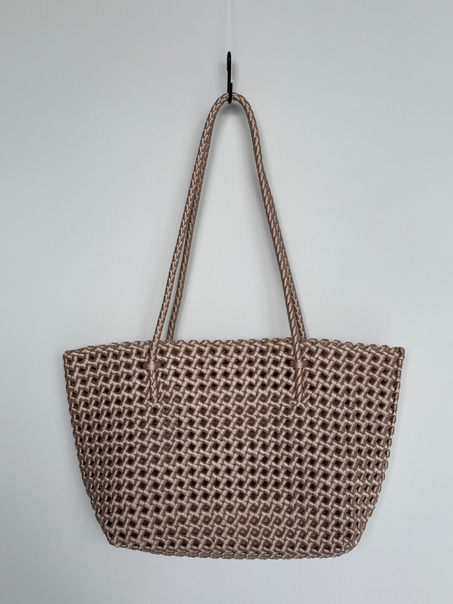 Geflochtene Braided Shopper Bag in Metallic-Gold mit langen Henkeln aus Stoff, an Haken aufgehängt