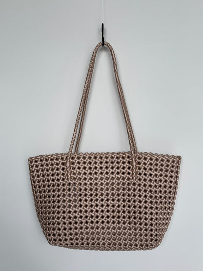 Geflochtene Braided Shopper Bag in Metallic-Gold mit langen Henkeln aus Stoff, an Haken aufgehängt