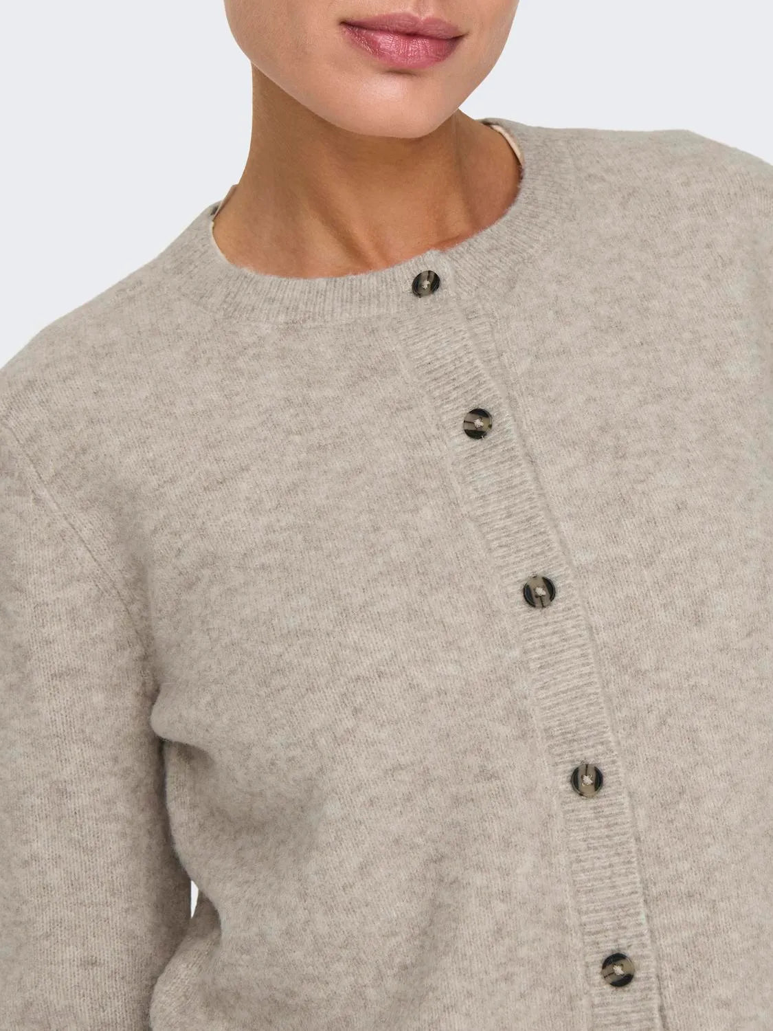 Nahaufnahme der Knopfleiste eines beigen Strick-Cardigans mit Rundhalsausschnitt von JDY.