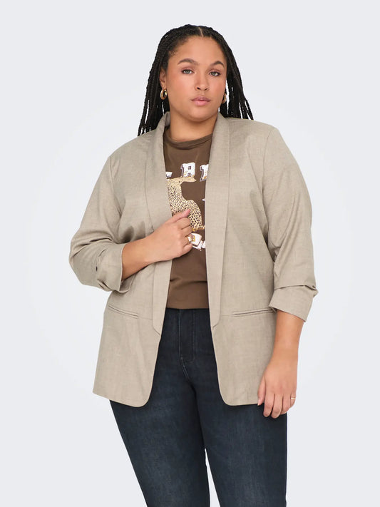 Model trägt den Only Carmakoma Elly 3/4 Life Blazer White Pepper Melange, kombiniert mit einem braunen Shirt und dunkler Jeans.