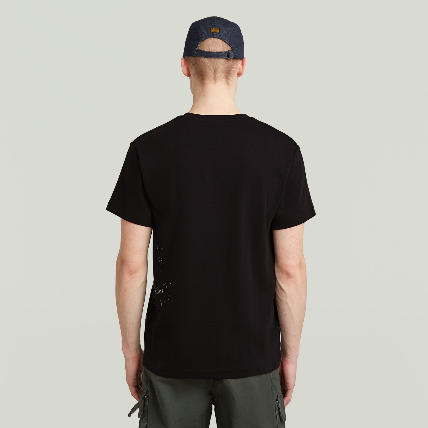 Rückansicht des G-Star Raw Sprayed T-Shirt - Black, schlichtes schwarzes T-Shirt mit dezentem Print am unteren Rückenbereich.