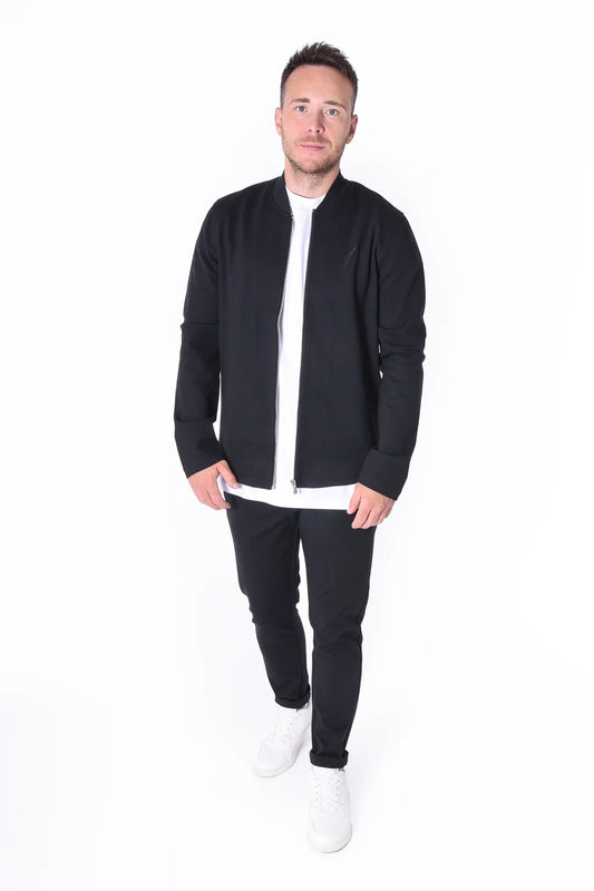 Komplettes Outfit mit der "Kleinigkeit Albert Feinstein" Hose in Schwarz, kombiniert mit weißem T-Shirt und passender Jacke – ideal für einen stilvollen Auftritt.