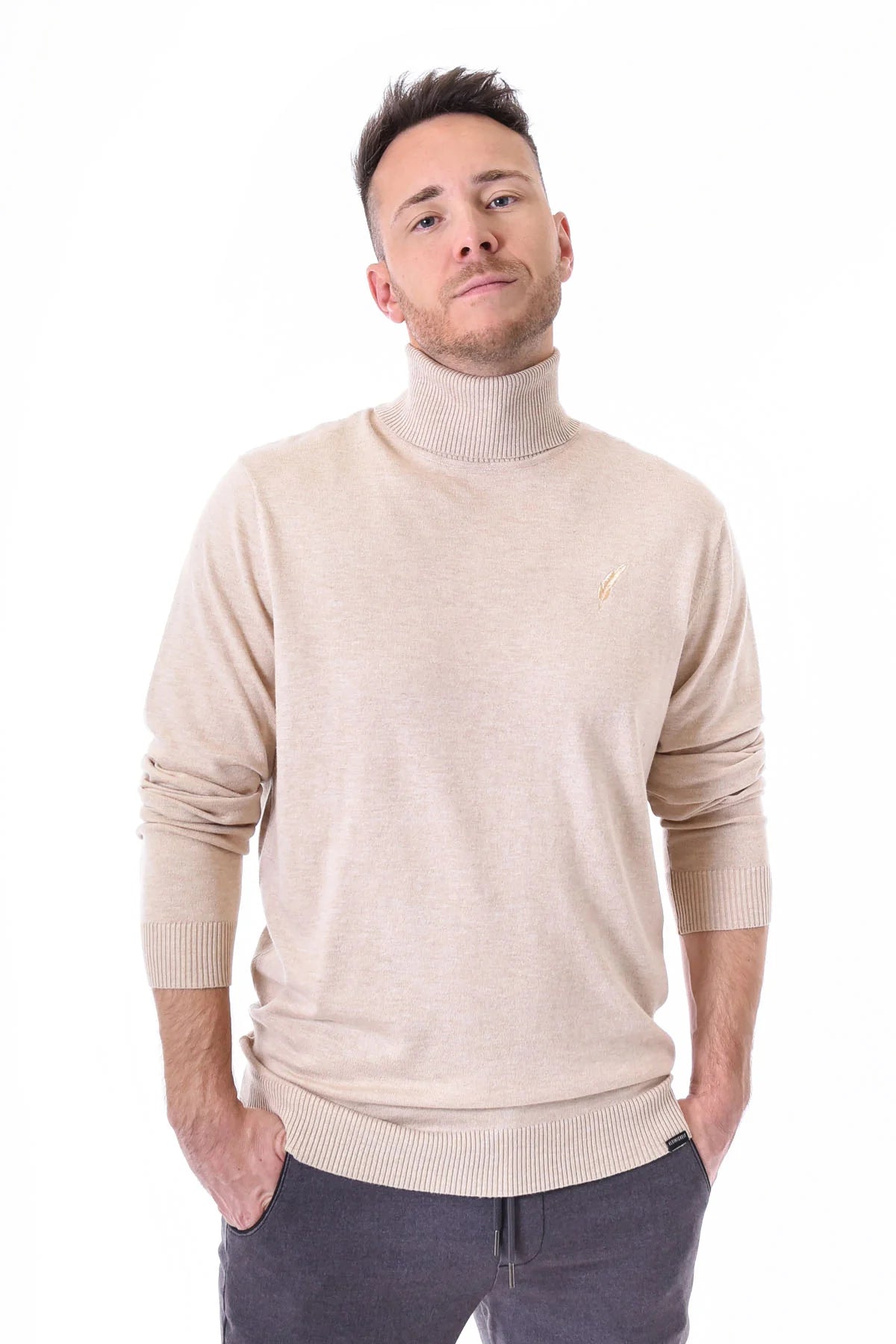 Mann trägt den Kleinigkeit Rolliver Kahn Light Beige Rollkragenpullover mit gerippten Bündchen und dezentem Logo. Stilvoller und bequemer Pullover für Herbst und Winter.
