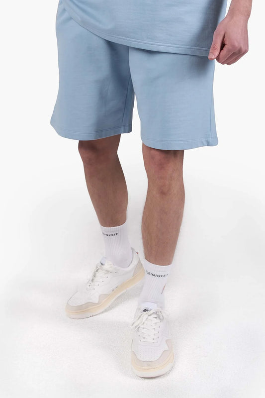 Modell trägt die Kleinigkeit Sticki Micki Shortpant Light Blue – leichte Jogginghose in Hellblau mit Stickerei, ideal für den Sommer.
