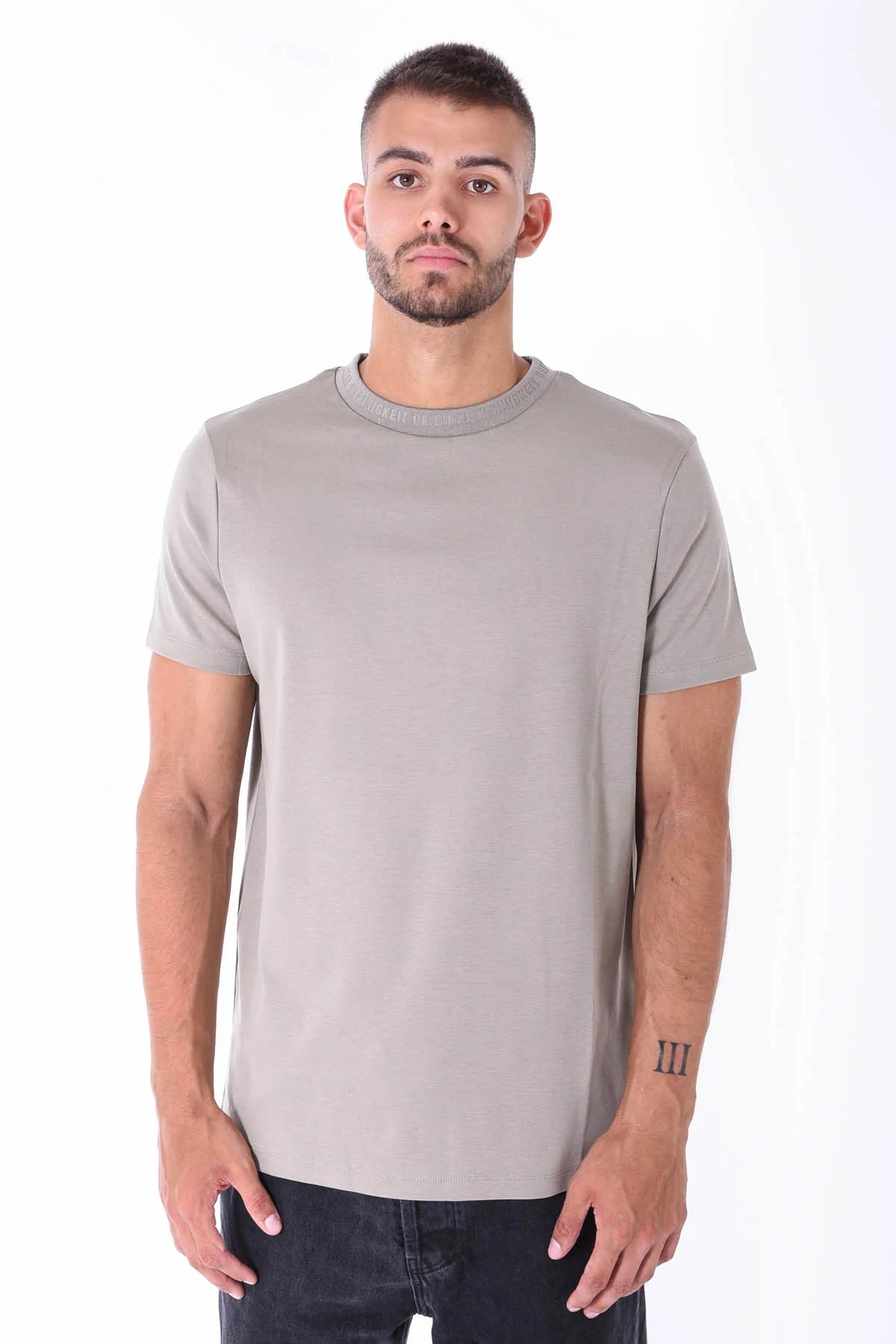 Herren-T-Shirt in Oliv von Kleinigkeit, mit geripptem Rundhalsausschnitt und eingeprägtem Schriftzug. Hochwertige Verarbeitung für einen modernen Look.