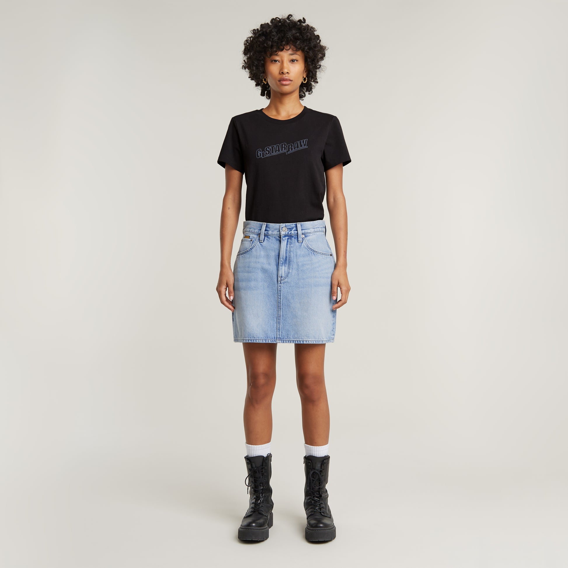 G-Star Viktoria Short Skirt Sun Faded Blue Cape kombiniert mit schwarzem T-Shirt und schwarzen Boots – Komplettlook