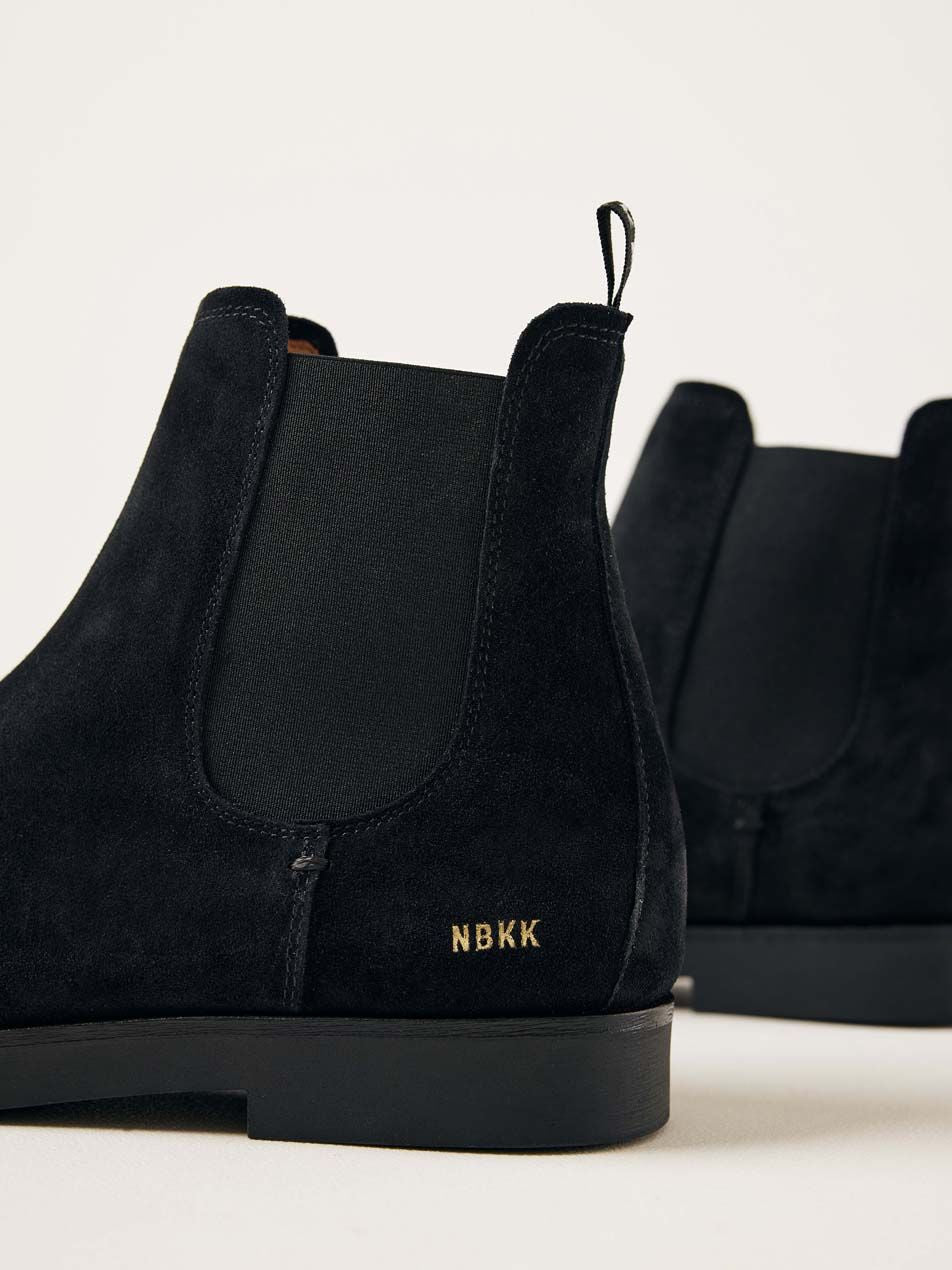 Rückansicht der Nubbik Logan Chelsea Stiefel aus schwarzem Wildleder mit goldfarbenem NBKK-Logo.