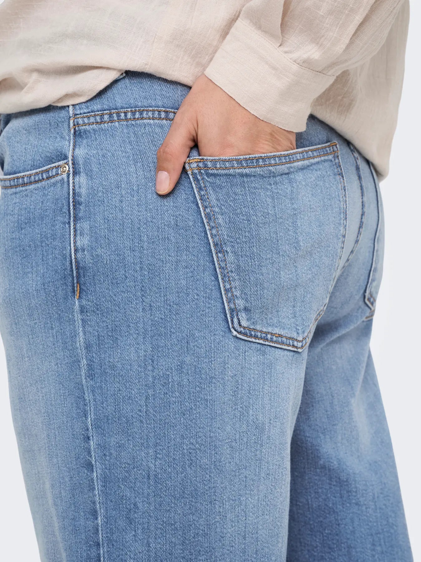Detailaufnahme der Only Carmakoma Sonny - High Waist Wide - Light Blue Denim: hellblaue Denim-Jeans mit aufgesetzter Gesäßtasche, Kontrastnähten und hochwertiger Verarbeitung.