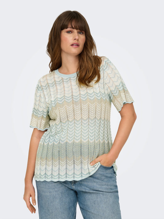 Model trägt das Only Vira Life Glitter Cloud Blue Top – kurzärmliges Stricktop mit Rundhalsausschnitt, Glitzerdetails und Wellenmuster in Blau- und Beigetönen, Vorderansicht