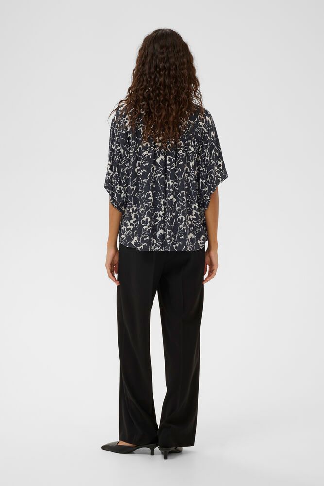 Rückansicht der Soaked Arjana Blouse - India Ink Outline Flower getragen mit weiter Hose, fließende Silhouette