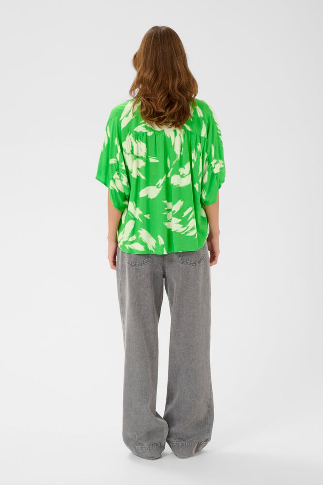 Rückansicht der Soaked Arjana Blouse - Vibrant Green Splash mit lockerem Schnitt und ausdrucksstarkem Print